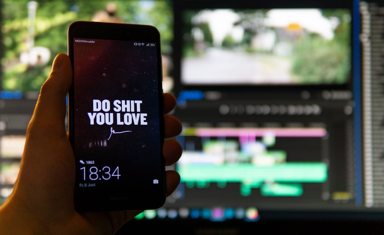 our-services-3 Close-up of a smartphone displaying an inspirational message against a video editing background.