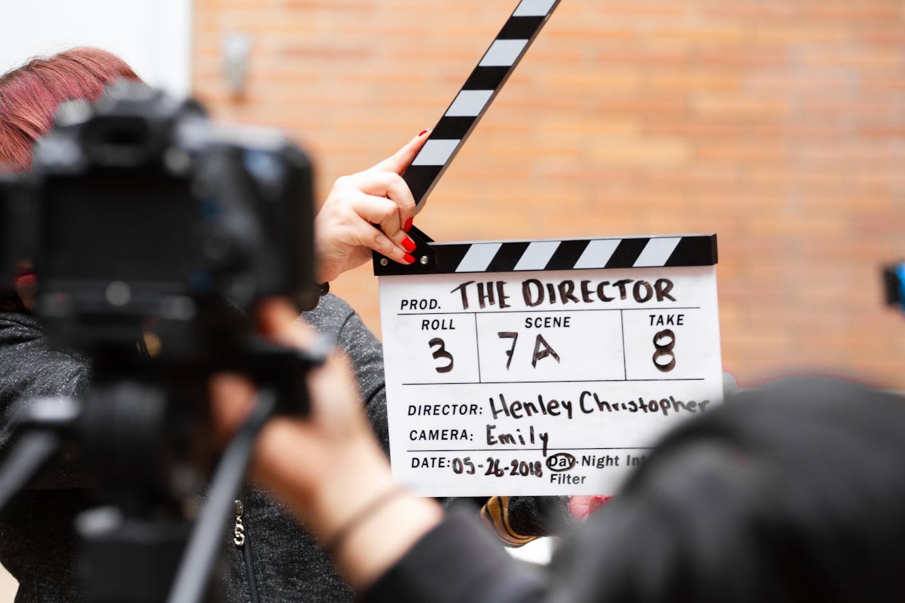 why-choose-us Close-up of film clapperboard in action with camera filming a take on set.