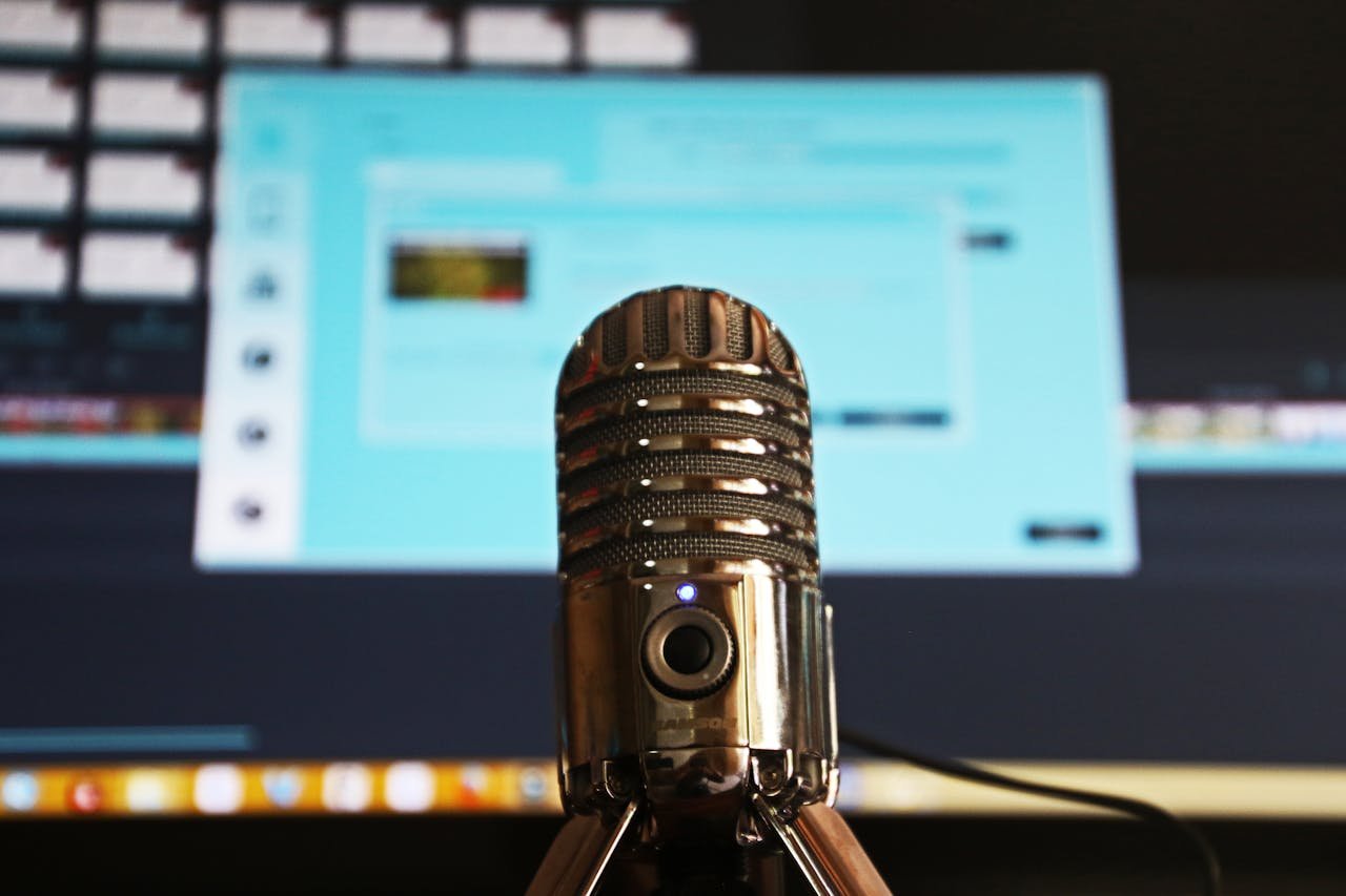 our-services-2 Close-up of a microphone with a blurred computer screen in the background, ideal for podcast themes.